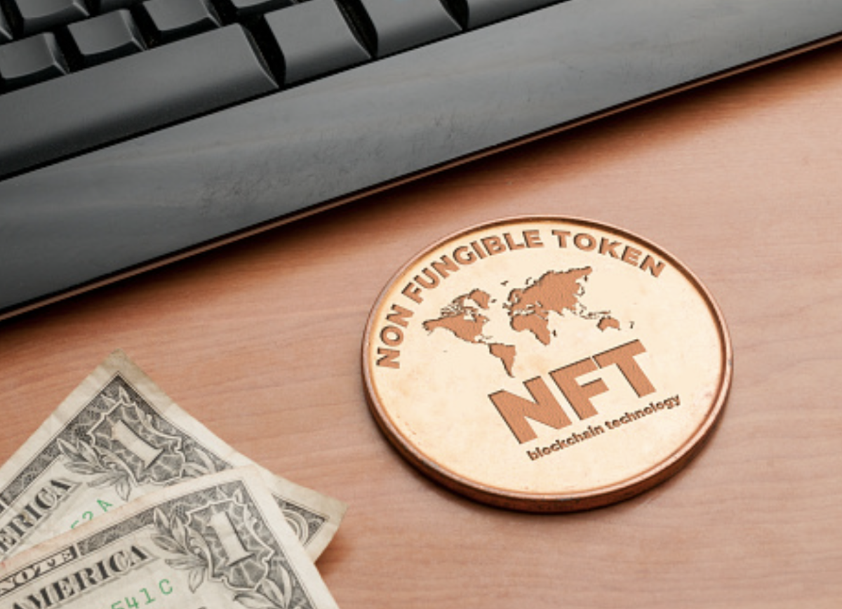 Non Fungible Token as a real coin in front of a computer. 